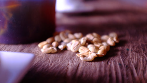 Granos de café trillado sobre una mesa de madera
