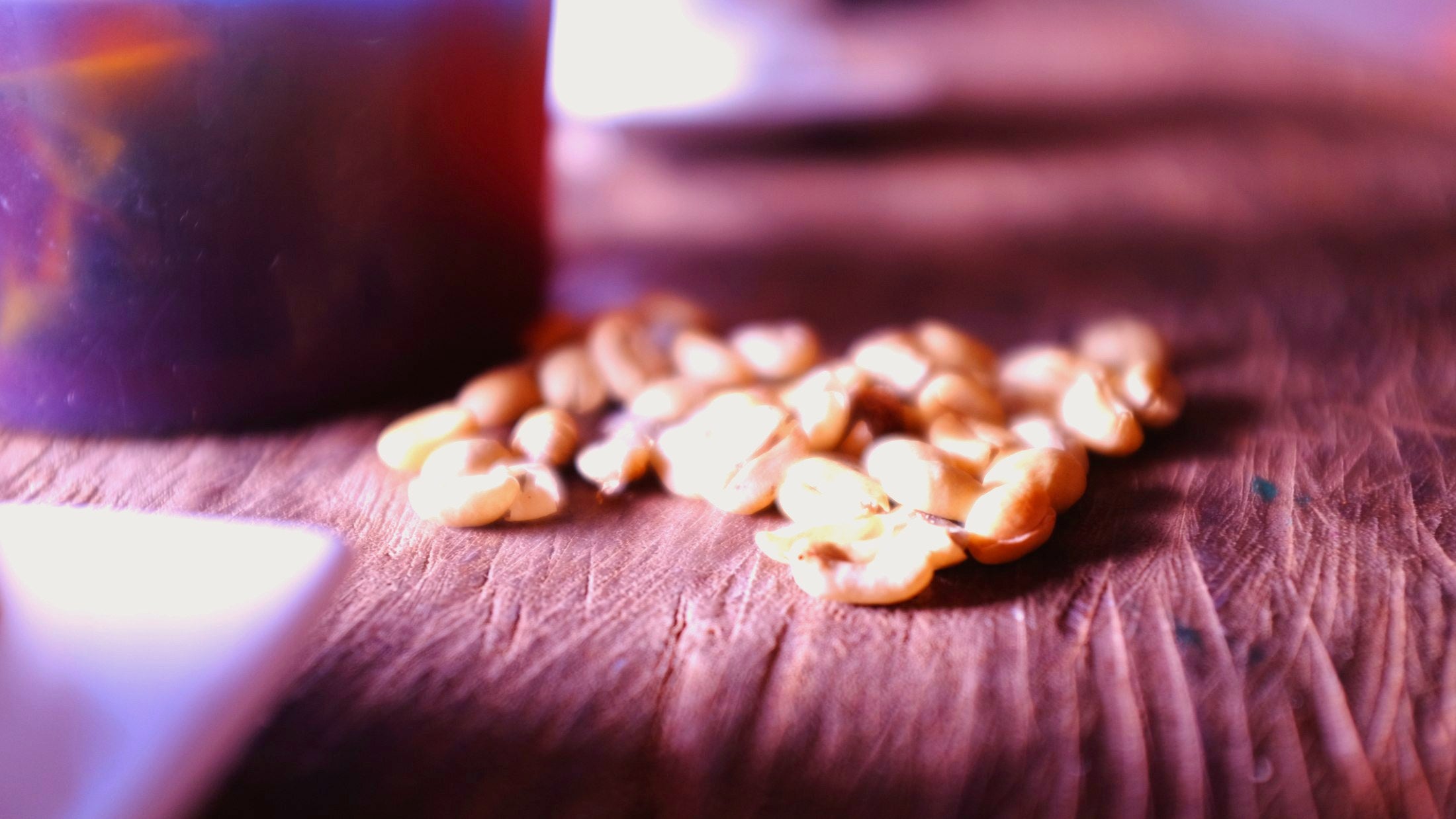 Granos de café trillado sobre una mesa de madera