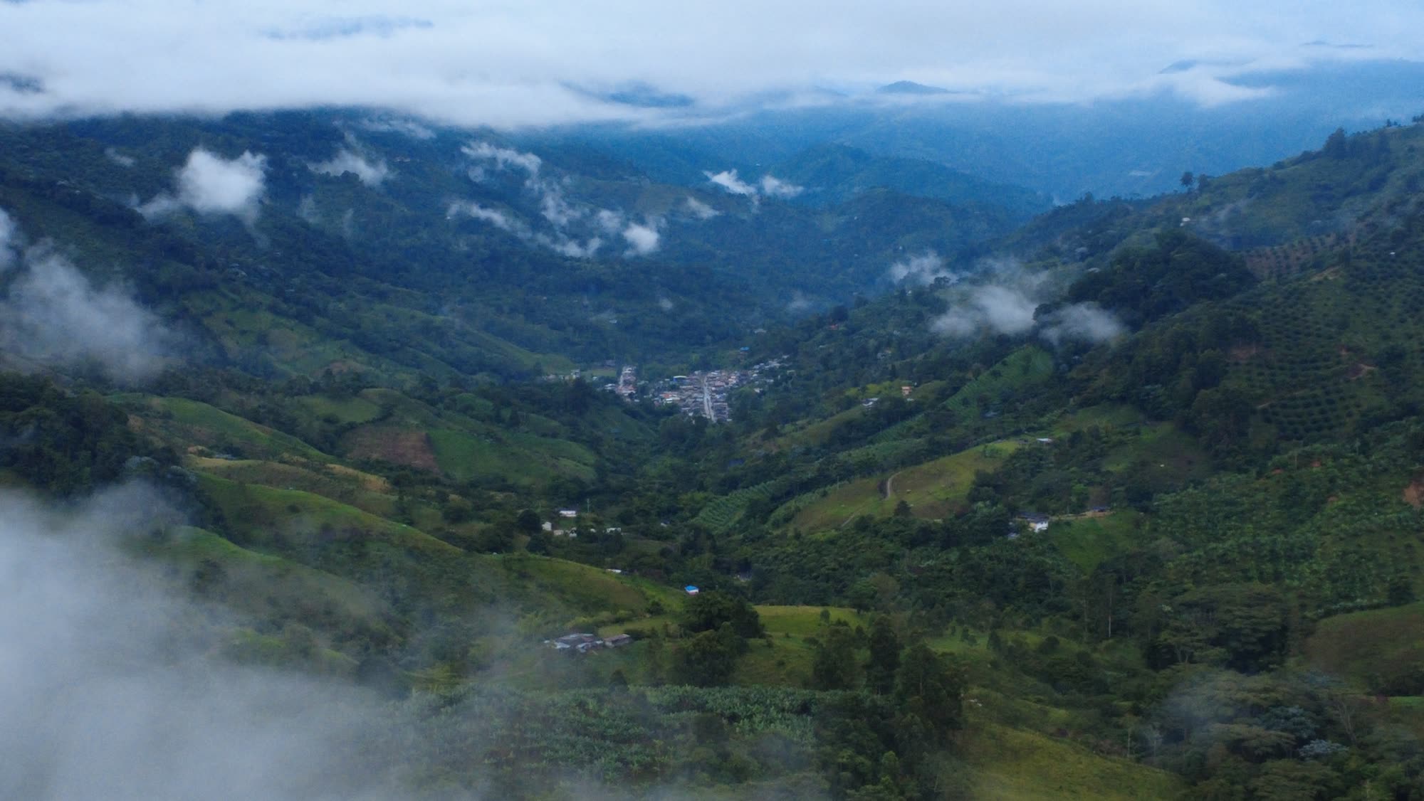 Low clouds over the coffee valley of Pijao, the town small in the distance