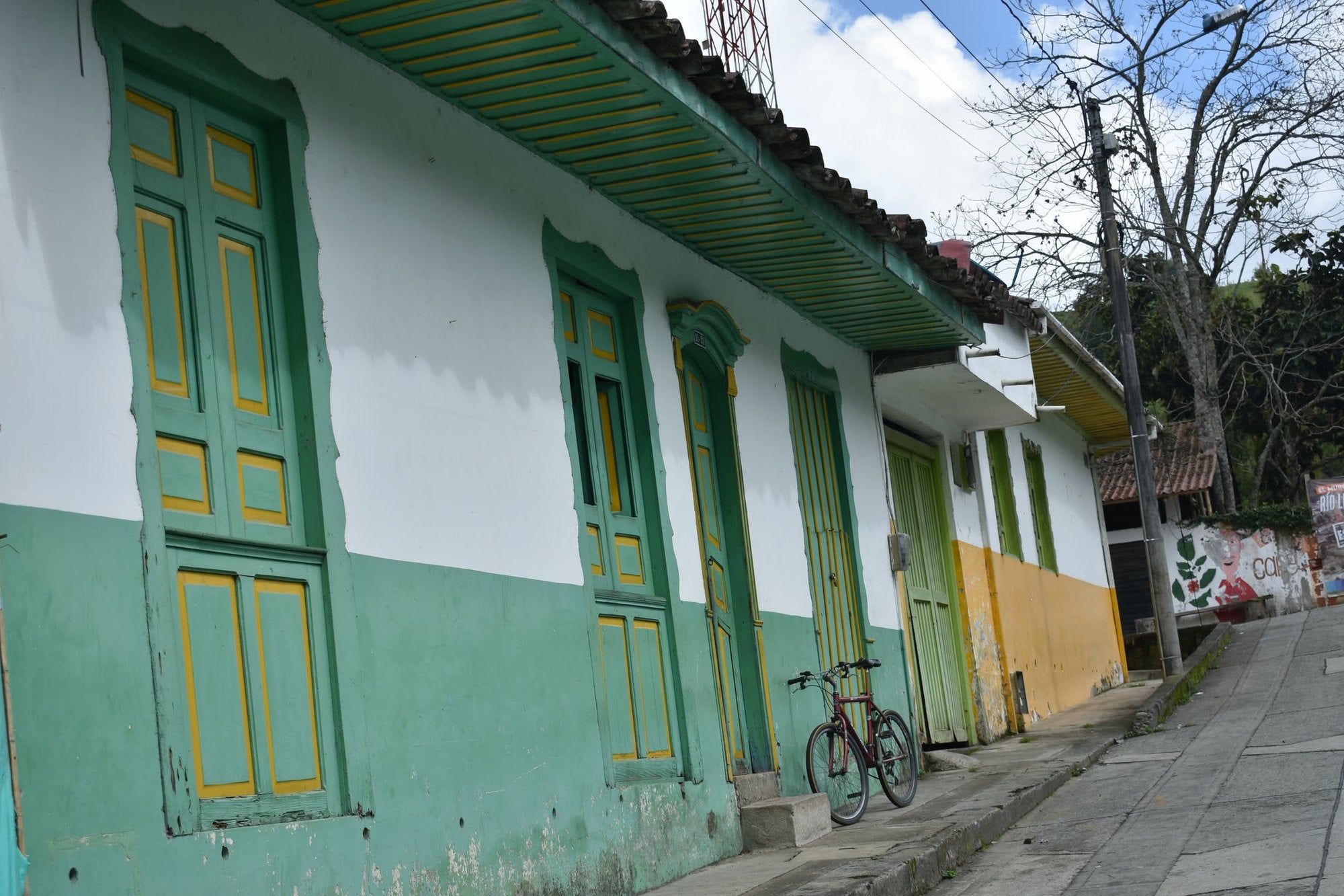 Eine Straße in Pijao mit grüner Fassade und gelben Fenstern