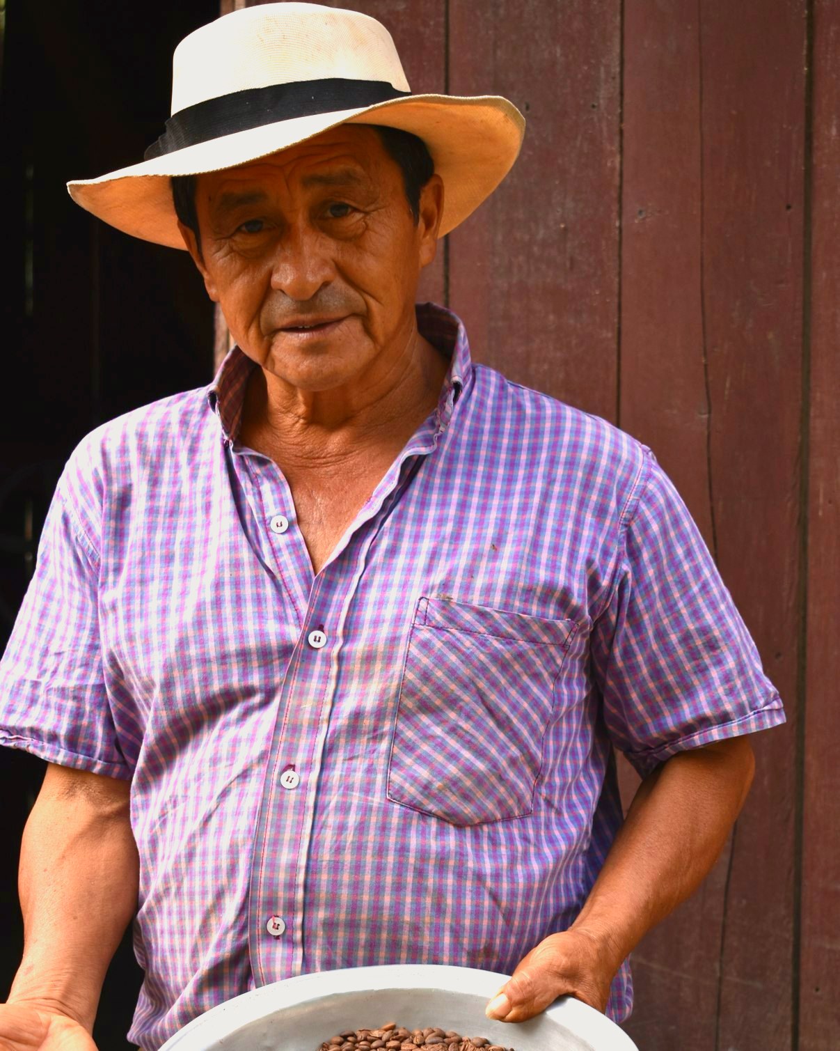 León Campo in a hat, holding a bowl of parchment coffee